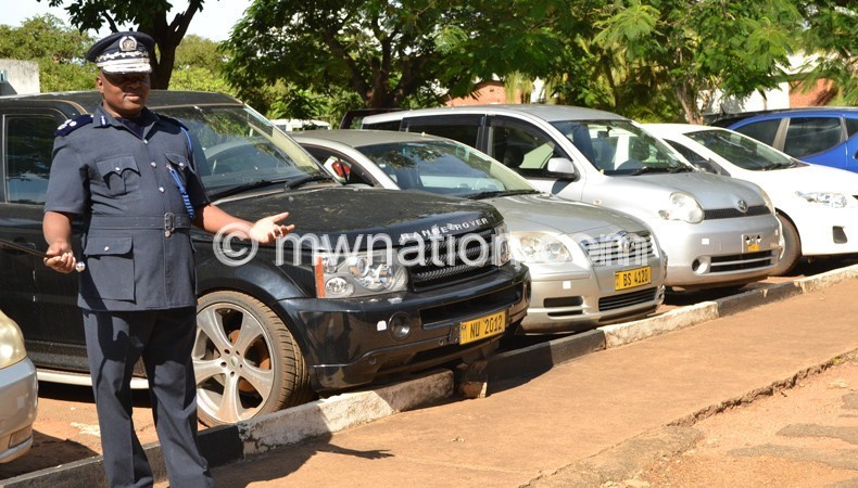 Deputy Inspector General of Police  Nelson  Bophani showing journalist some vehicles impounded in connection with cashgate