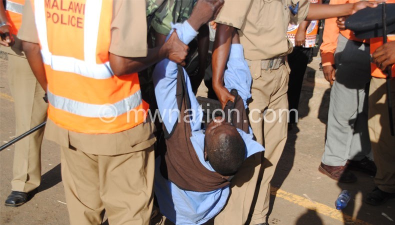 Police carry an injured person during the Thyolo fracas