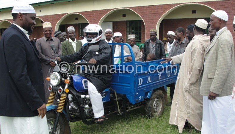 Muhammad (L) handing over the motorcycle ambulance to Muslims