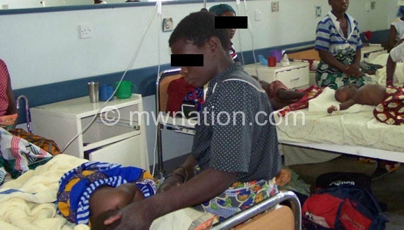 Four children share a bed in the paedriatic ward at Kamuzu Central Hospital