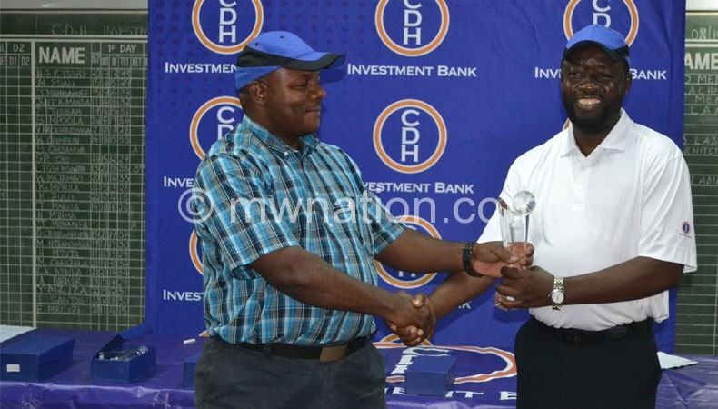 Esau (L) presenting a cheque to Penemulungu  after the event