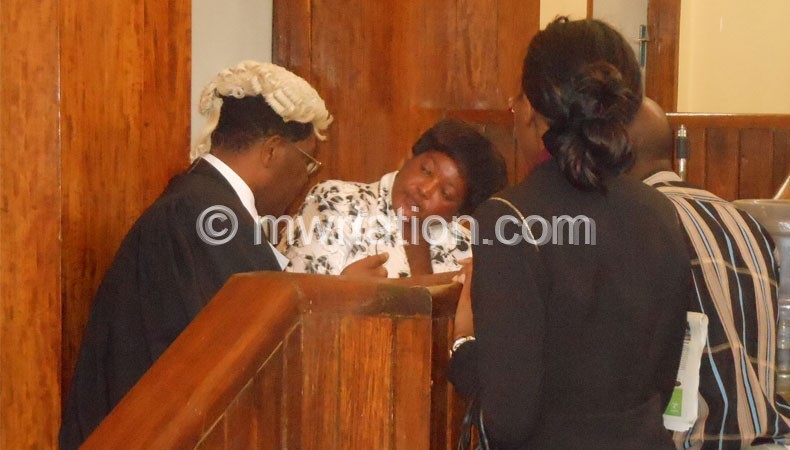 Treza Senzani (In White) consulting with her lawyer, Mhura 