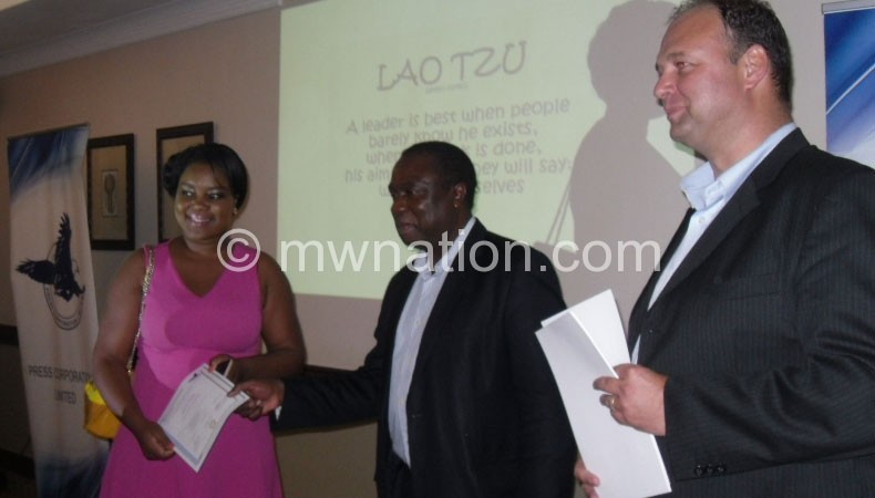 Chikaonda (C) handing over a certificate one of the graduates