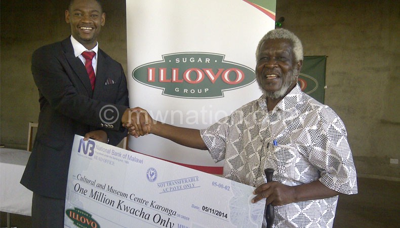 Nyamilandu (L) hands over the cheque to Mwakasungula