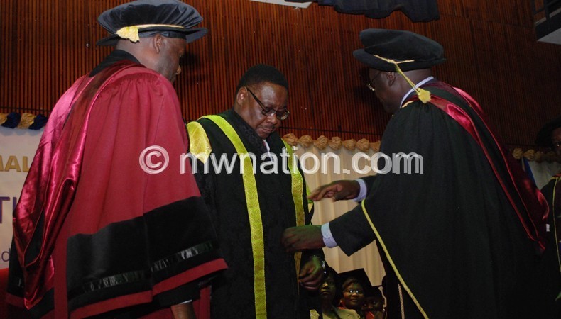 UNIMA Registra and vice Chancellor confering president Peter Mutharika as the University's new Chancellor at Chancellor colloge on Wednesday.Pic by Govati Nyirenda. Mana