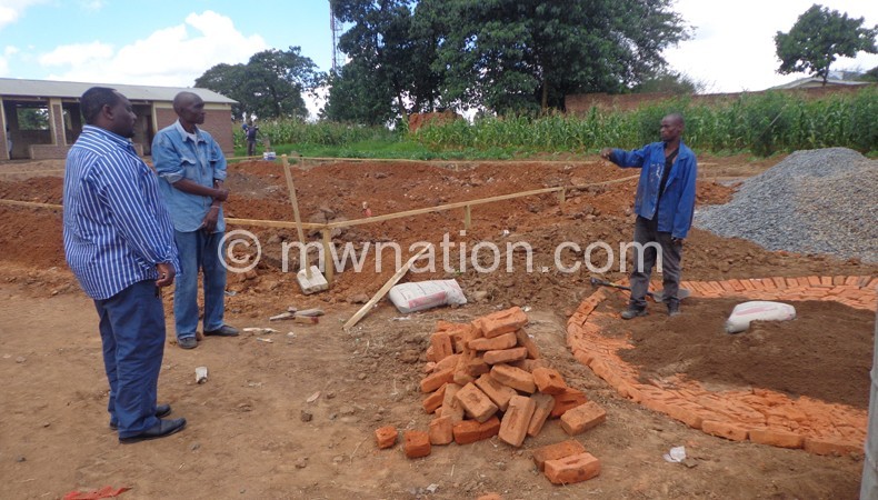 Flashback: Construction workers briefing Masangwi (L) on progress of the project