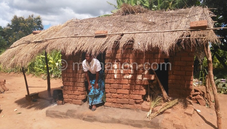A woman walks out of her dilapidated home