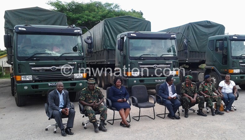 Malawi and Tanzanian officials pose in front of the trucks  carrying relief items