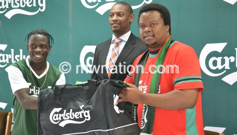 Chirwa (R) presents a travelling  bag to Kamwendo (L) as Nyamilandu looks on