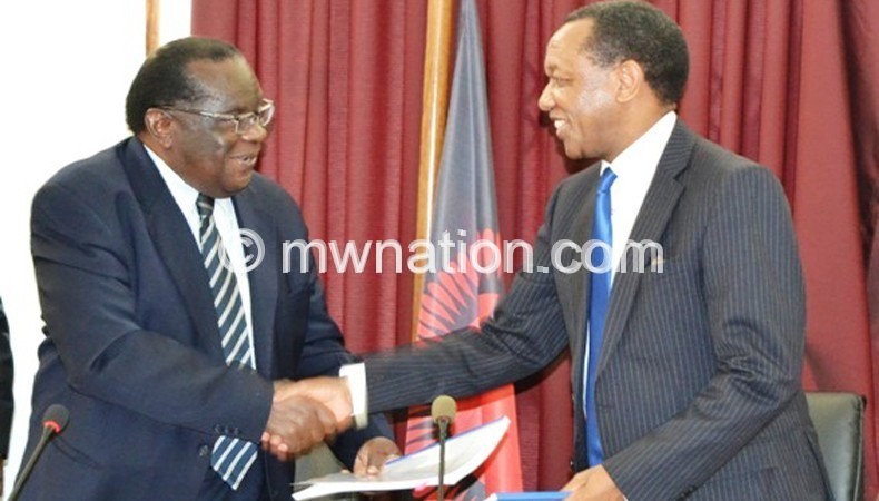 Minister of Finance, Economic Planning and Development Goodall Gondwe and Mpinganjira (R) exchange contract documents
