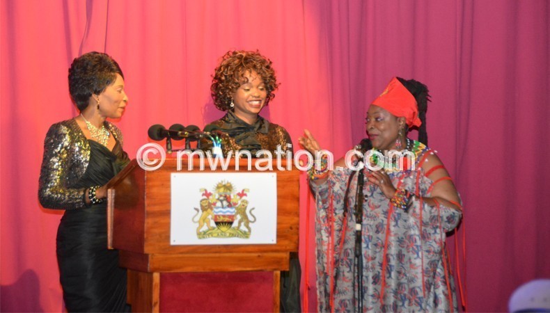 Mutharika (L) joins Chidzanja-Nkhoma in song as Chilima (C) looks on 