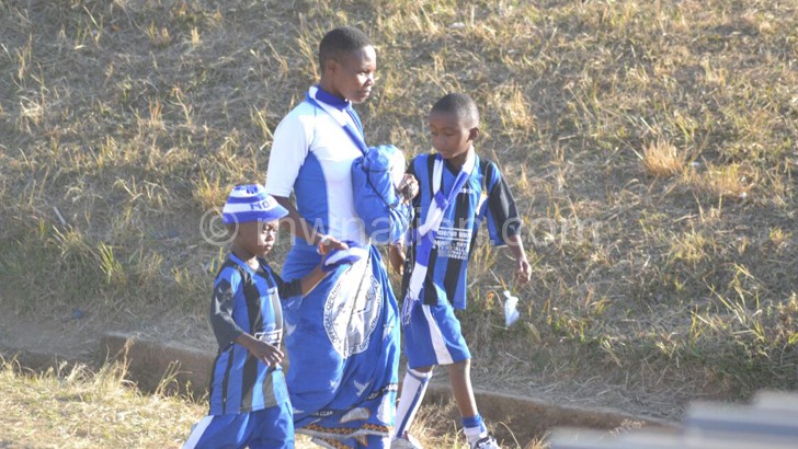 A woman leave Kamuzu Stadium with her children after violence erupted during match  