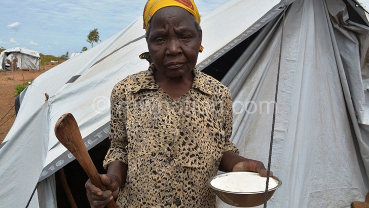 Mwaona Bote walks out of her shelter to prepare food