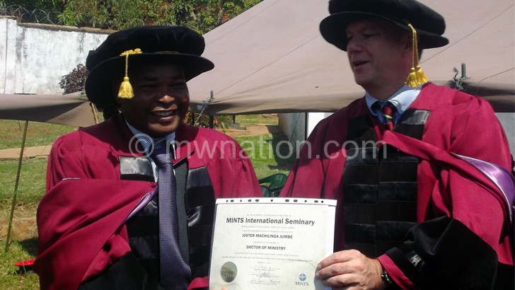 Jumbe (L) receives his degree from Zugg