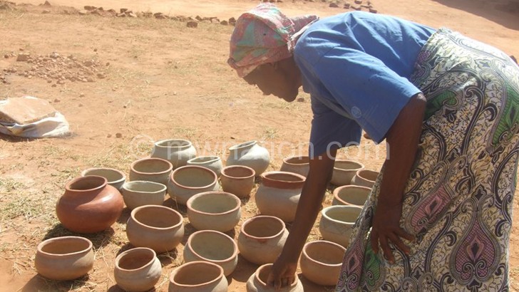 An elderly woman admires pots they made