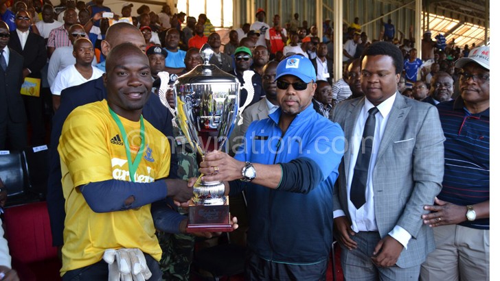 Veep Chilima hands over the trophy to Nomads captain Richard Chipuwa