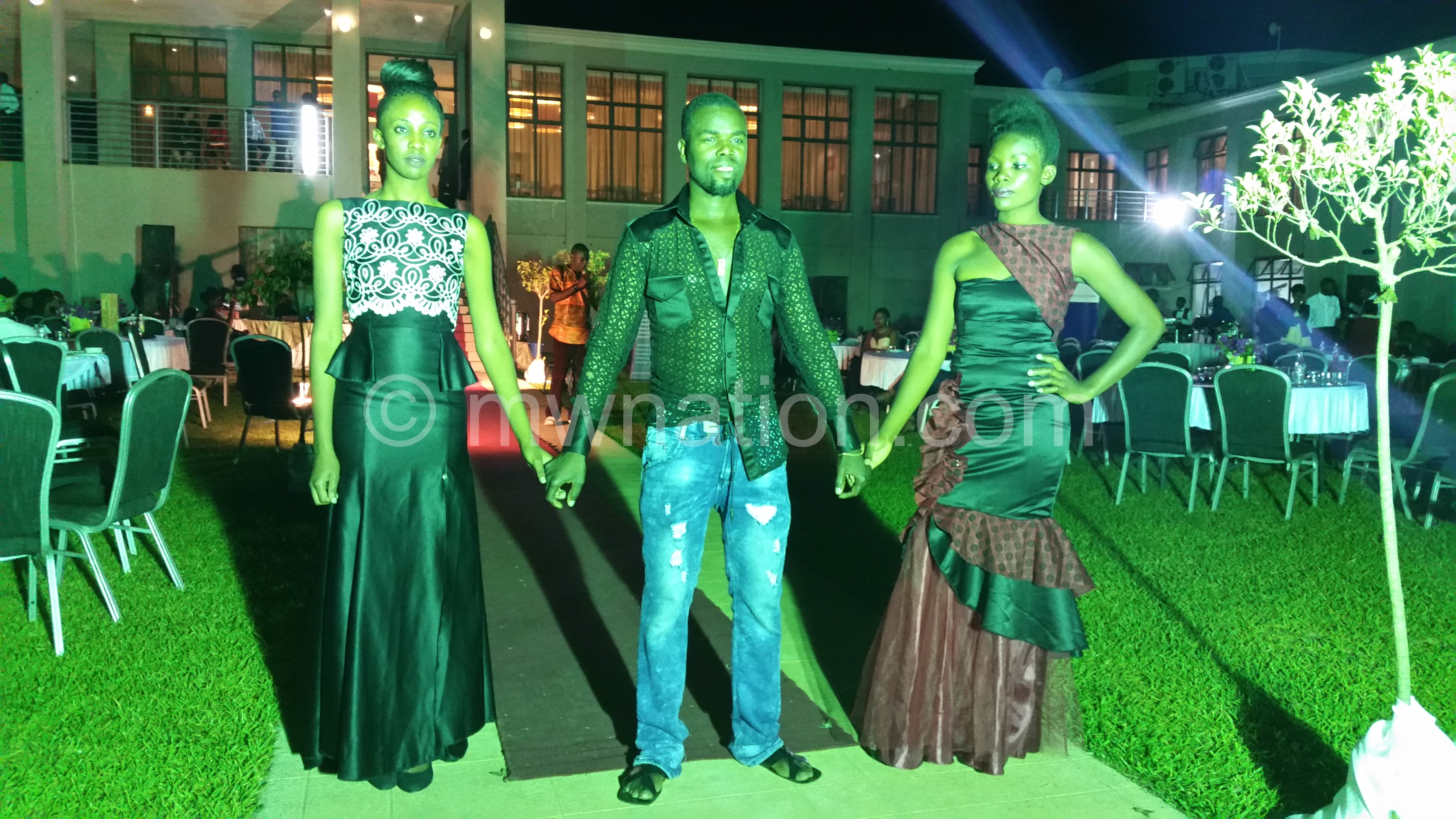 Clemoh Sato (C) poses with models wearing his designs at the Mzuzu Fashion Week
