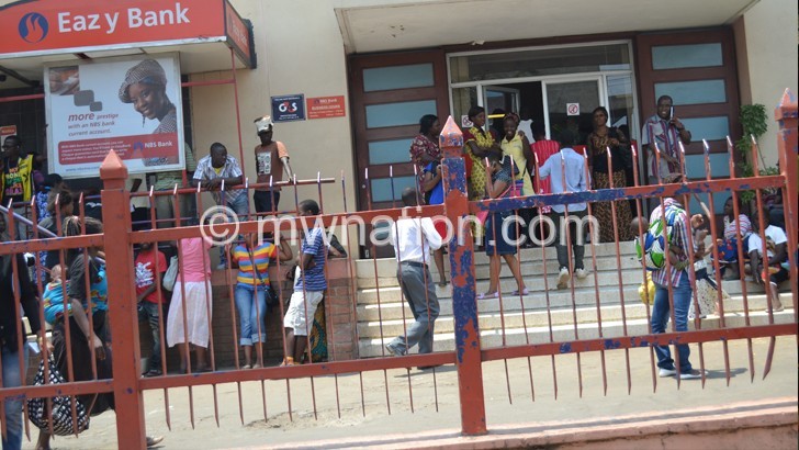 Hopeless: Some of the frustrated customers outside  the bank’s Limbe Branch