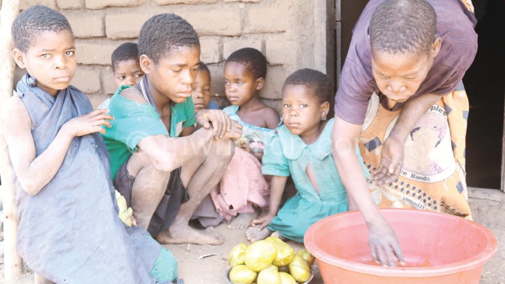 Chilumpha and her children share some cooked mangoes