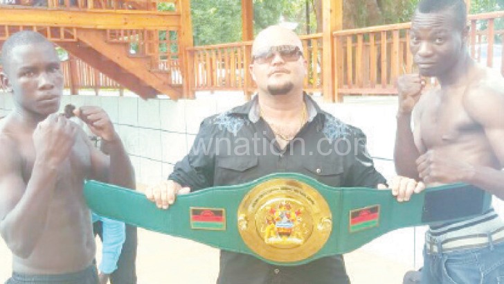 Masamba (R) and Msoliza (L) size up against each other as  Rousseau holds the belt 