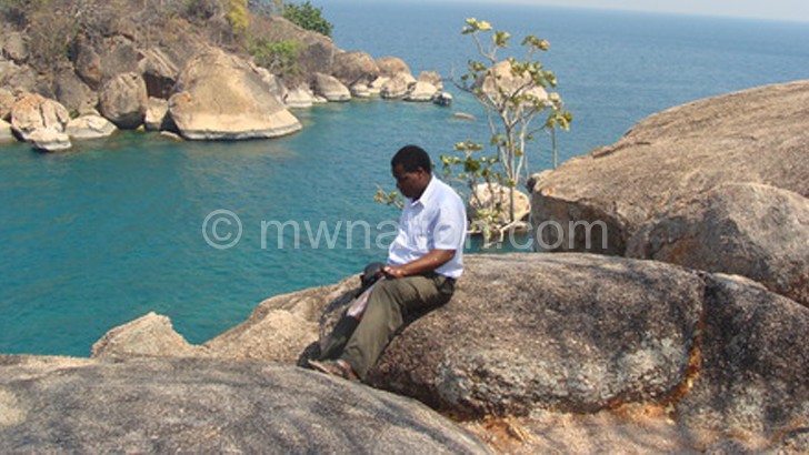 A tourist feels the cool breeze from Lake Malawi National Park section, a world heritage centre