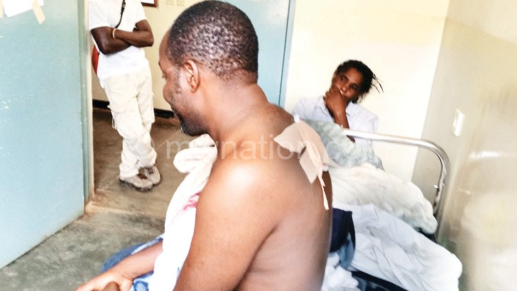 Kumwenda showing bullet wounds on his back
