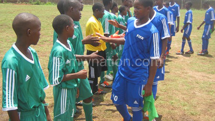 Zomba (in blue) and Phalombe players greet each other before their match 