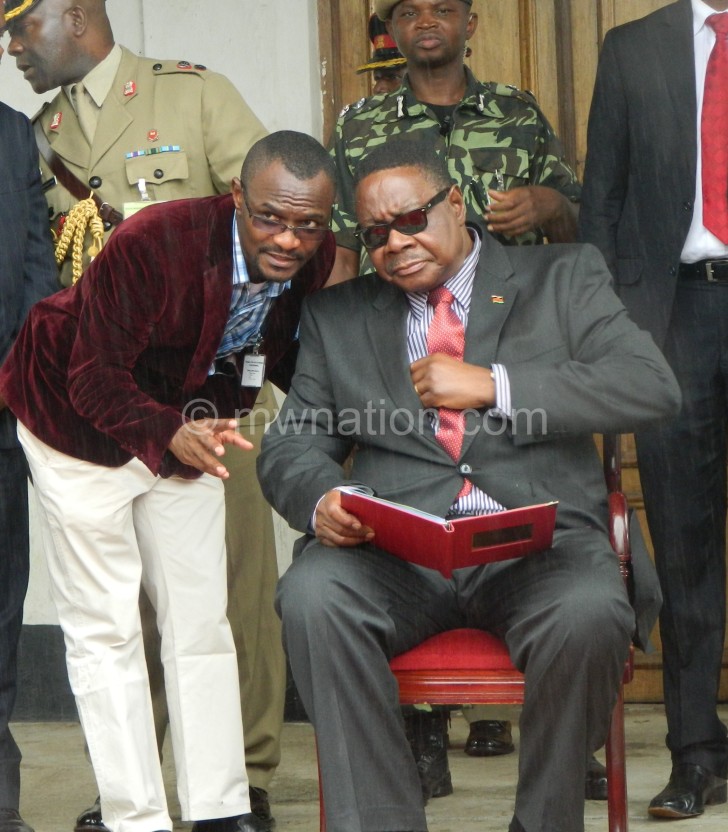 One of Mutharika’s aides Ben Phiri (L) consults him at a public rally