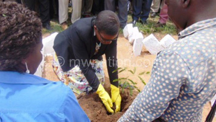 Botomani plants her tree during the event 