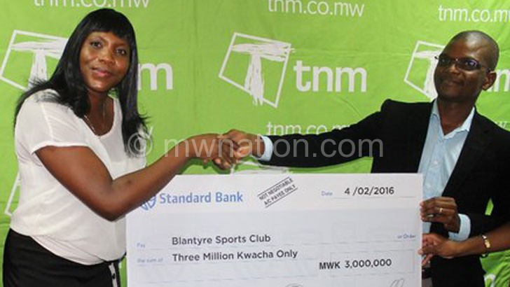 Makata (R) presents a dummy cheque to Muguvu-Karuku 