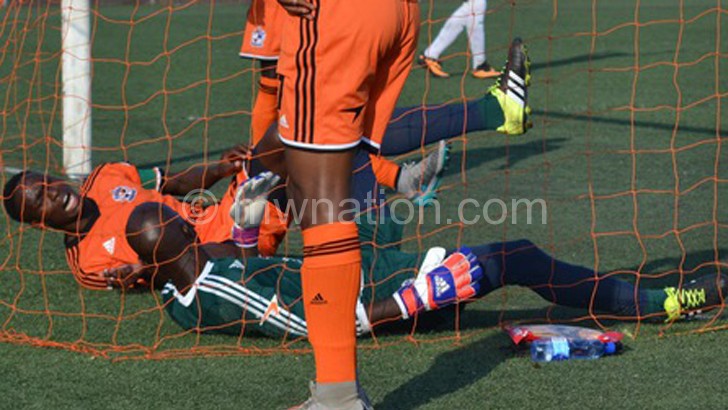 Nomads midfielder Mike Kaziputa (L) goalkeeper Phiri lies helplessly after conceding a goal against Mafco 