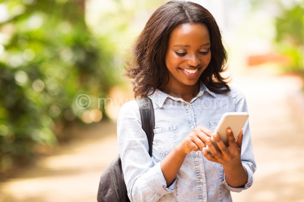 happy young african american uni student using cell phone