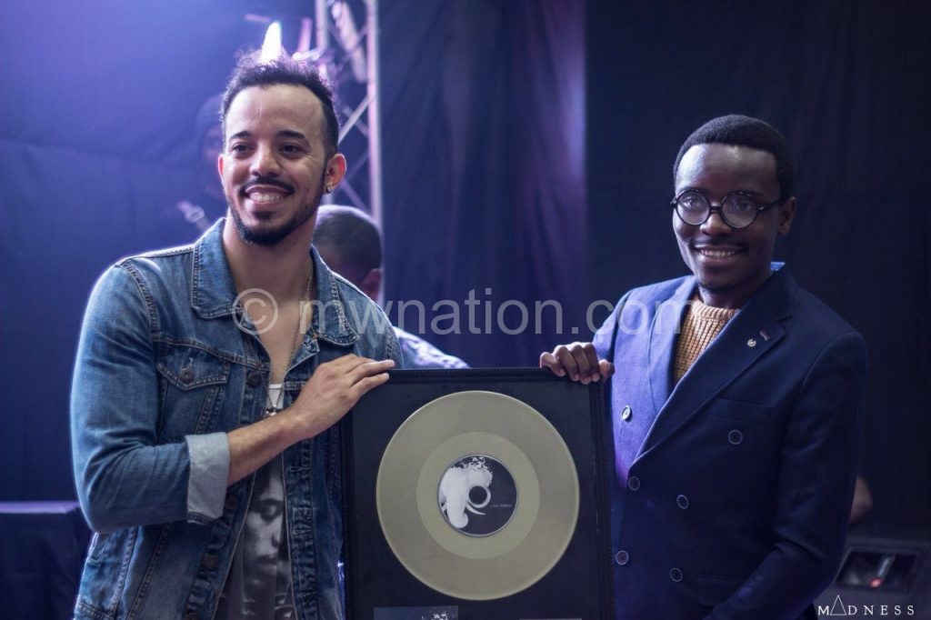 Theo (L) presents Namadingo with a copy of the album