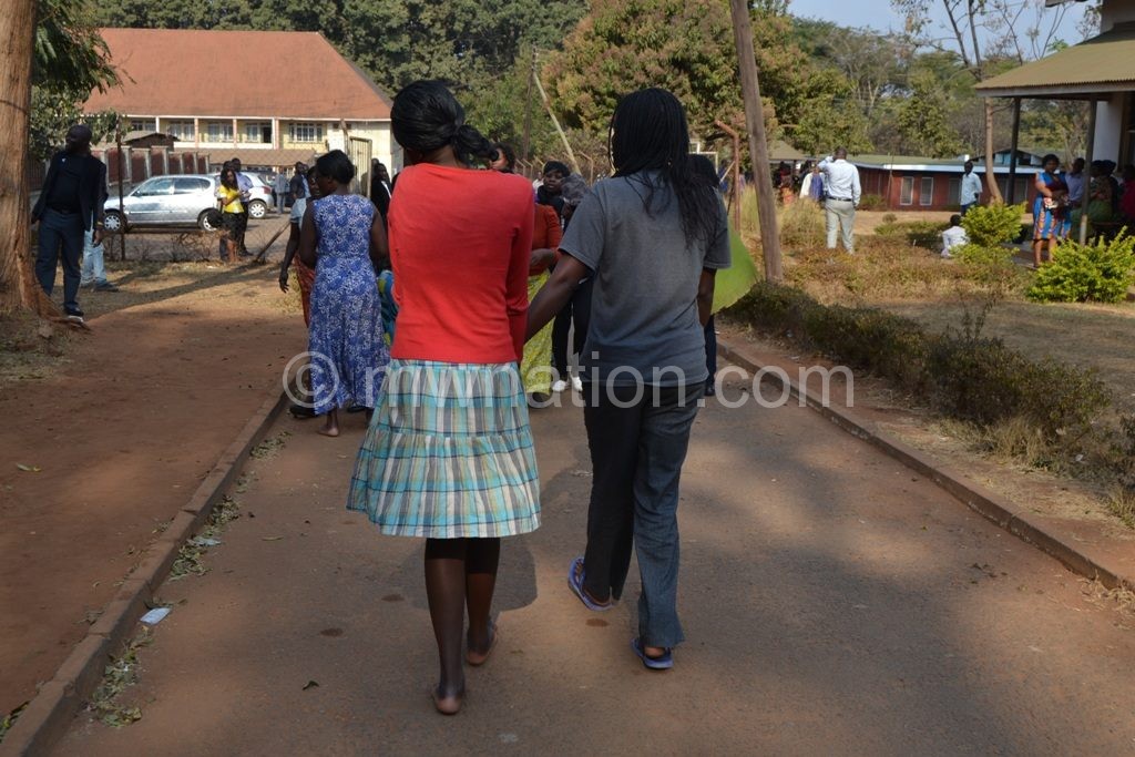 Out on bail: Some of the KCN students walk backwards to their  freedom to avoid cameras