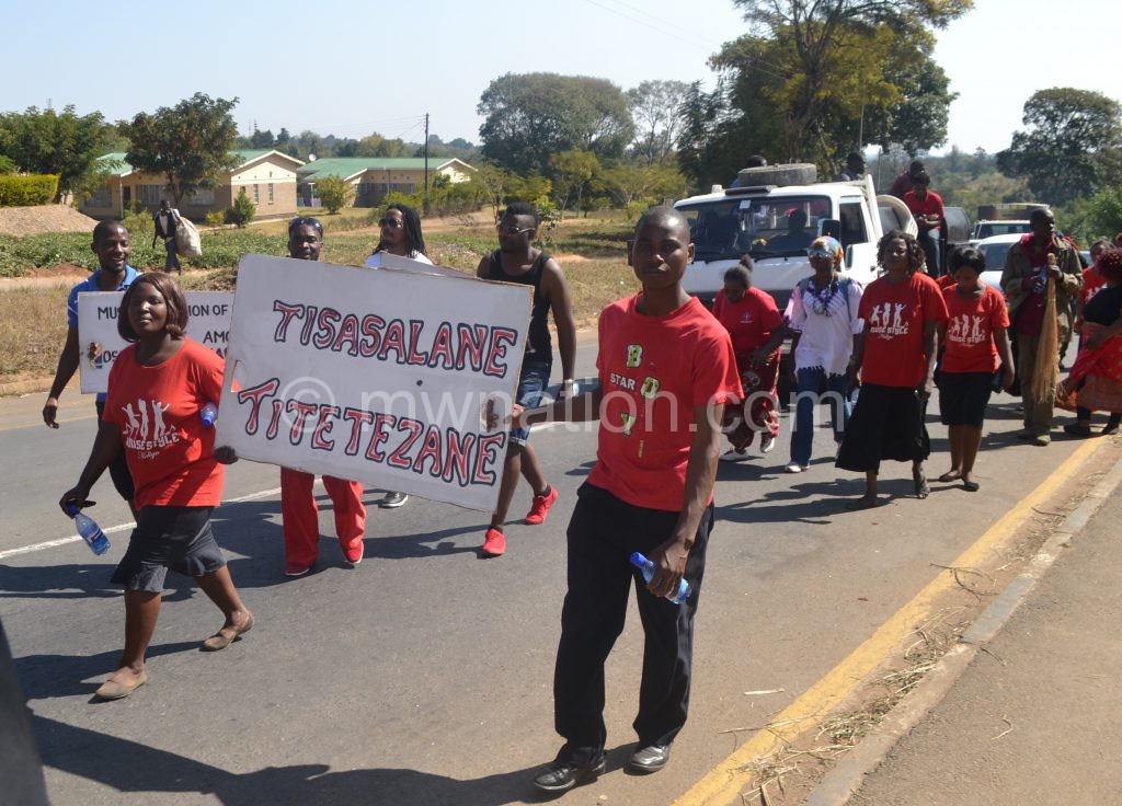 The musicians hoist a placard during the march in Blantyre