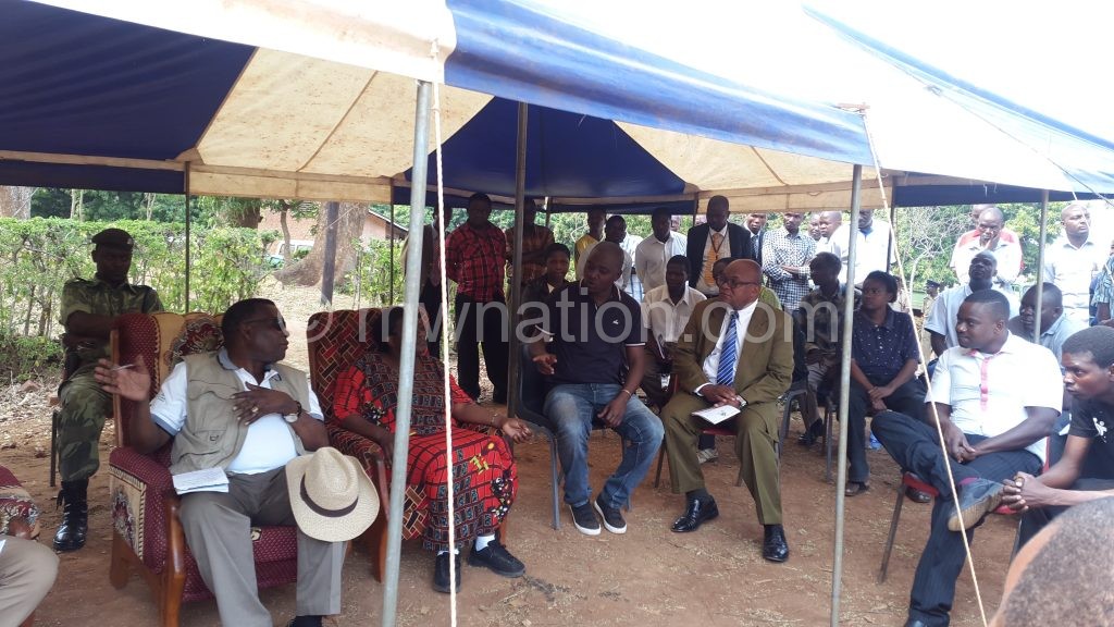 Chaponda (Front L) tries to reason with the group’s representatives as the villagers chanted in protest nearby