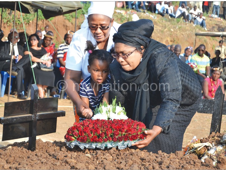 Mbendera’s wife Aida, and a grandchild being assisted to lay a wreath by Ella Tsukuluza, wife of bishop Charles Tsukuluza, founder of Revival Life Church