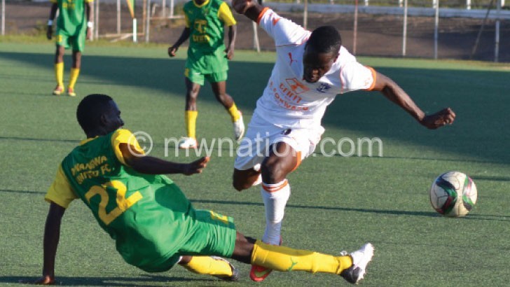 Wanderers’ Peter Wadabwa (R) is stopped by a Dwangwa defender in their first-round encounter 