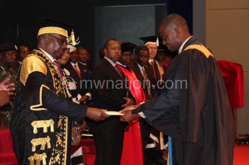Mutharika (L) congratulates one of the graduates 