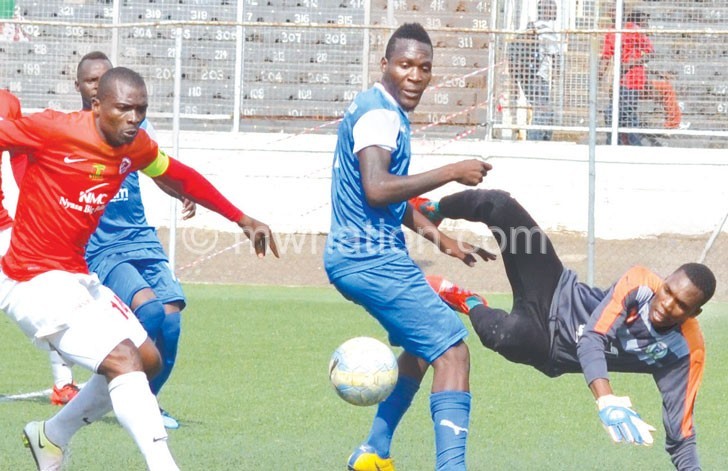 Karonga United goalkeeper Lloyd Munthali (R) makes a save to deny Bullets