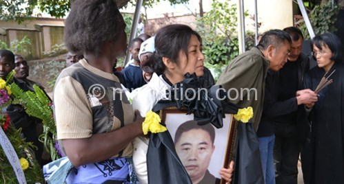 Zhou Feng's widow (2nd from L) and other symphathisers during the funeral service Sunday