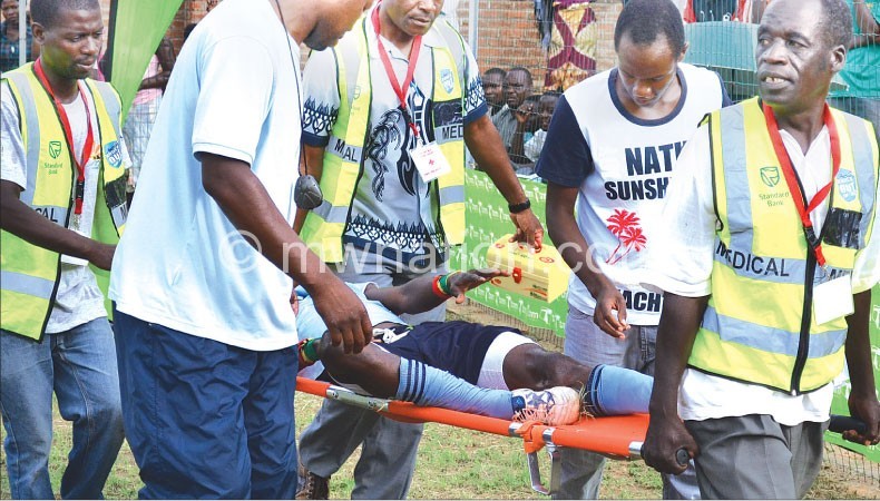 An injured Silver Strikers player being taken off the pitch for treatment