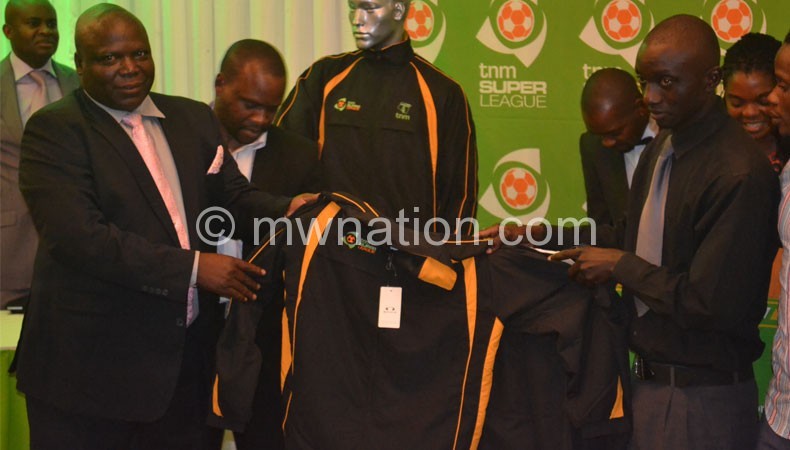 Saidi (L) makes a symbolic presentation of the new kit to Azam Tigers captain Malumbo Gondwe
