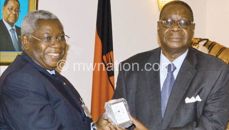 Mutharika (R) receives a gift from Shija