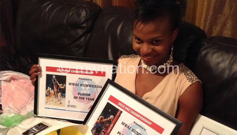 Mwawi shows off one of her awards 
with a team official