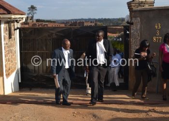 Enock Chibwana (L), prosecutors in the Directors of Public Prosecutions (DPP), Malunda (2nd L) and journalists leaving Mphwiyo's house yesterday
