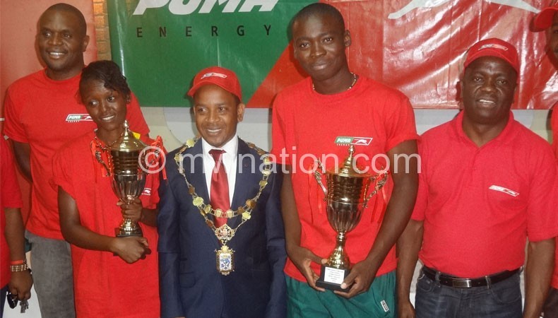 Tennis champions Ishmael (2ndR) and Shufa Changawa (2ndL) carry trophies as they pose with (R) Lanjesi, Chalamanda (3rdR) and and LTAM president Francis Mwansa