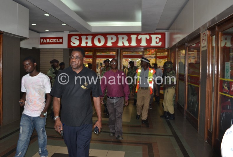 Triumphant: Kapito (in front) and Mayaya (in the purple shirt) walk out of Shoprite