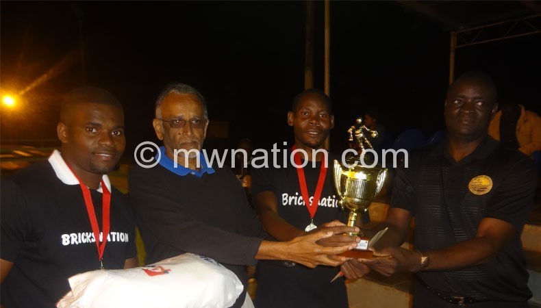 Bricks captain Makaka (C) receives trophy from Meet board member Daulos Mauambeta (R) and Sports Council board member Khrishna Achuthan