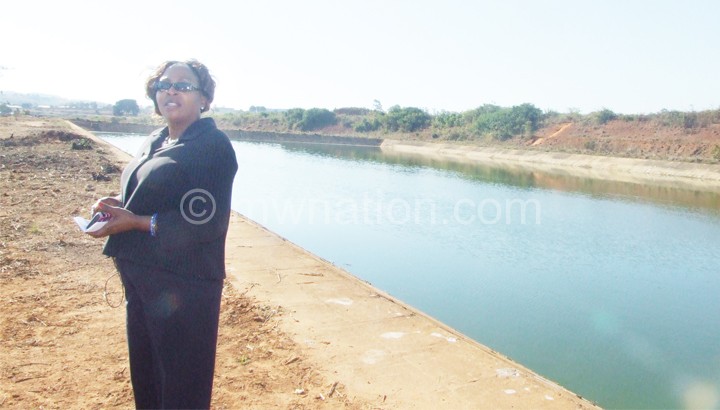 Nyirenda poses in front of one of the ponds linked to the sewerage system